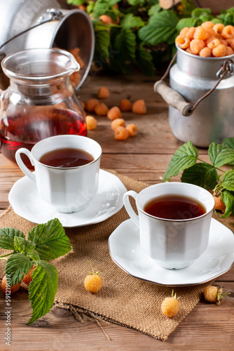 Flavored raspberry tea. Vitamin hot steaming drink with natural berries on wooden table