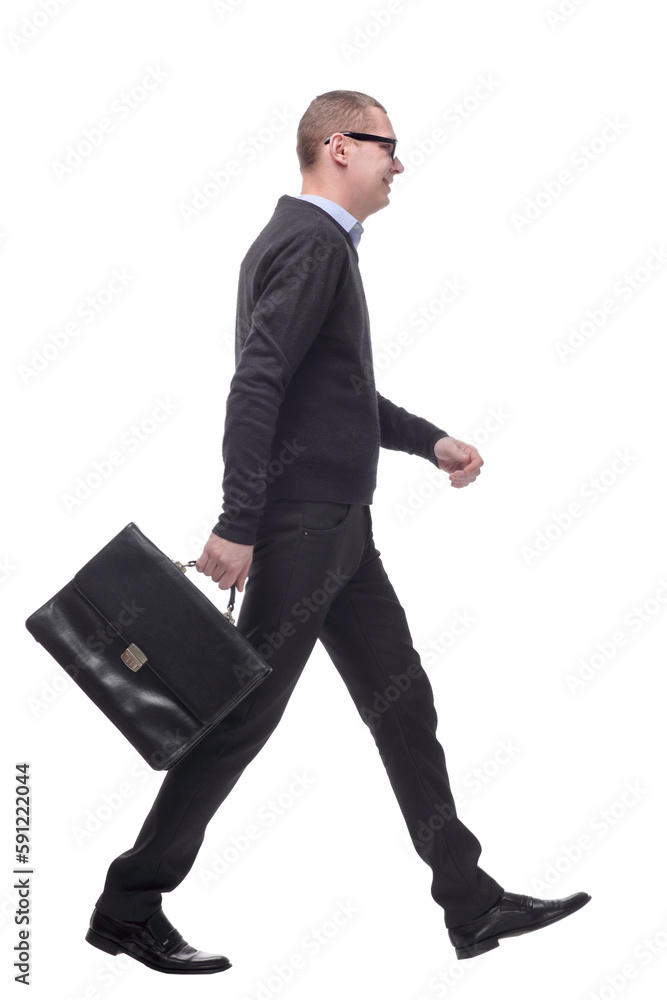 Full length side view picture of a young business man walking with a suitcase in his hand and a smile on his face Full length side view picture of a young business man walking with a suitcase in his hand and a smile on his face
