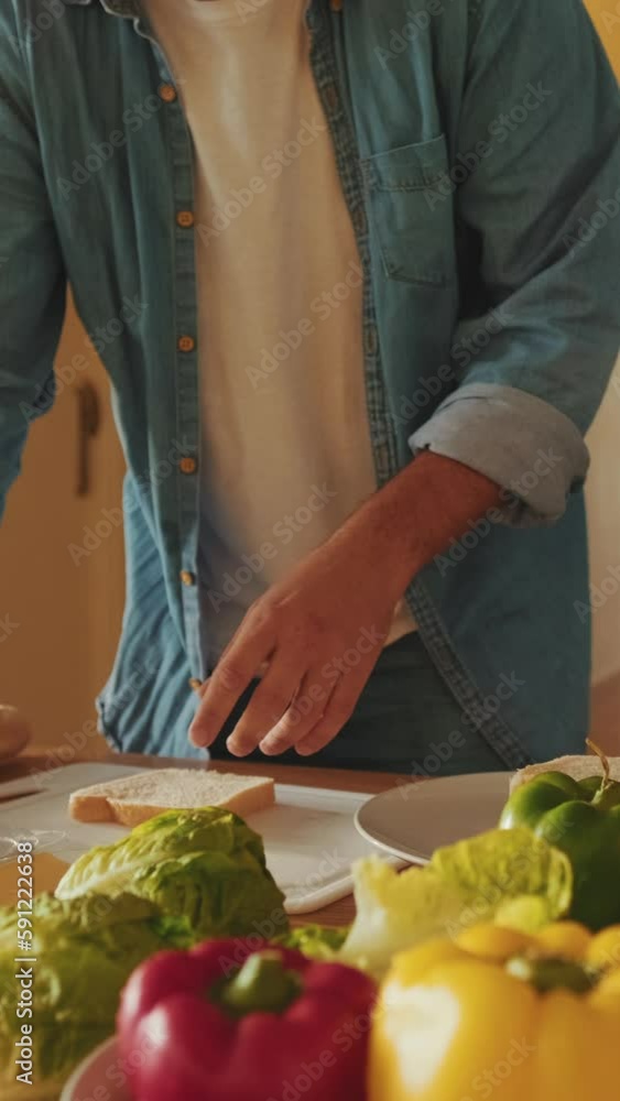 Close-up of hands of young man cooking sandwich standing in the kitchen Close-up of hands of young man cooking sandwich standing in the kitchen