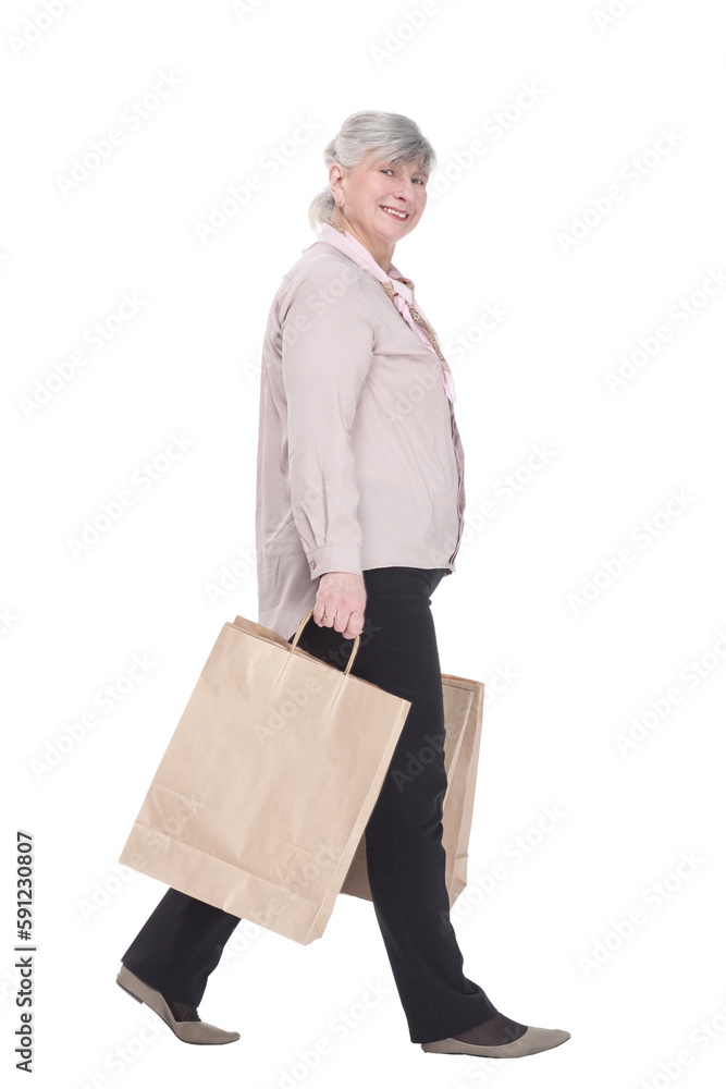 smiling old lady with shopping bags striding forward . smiling old lady with shopping bags striding forward .