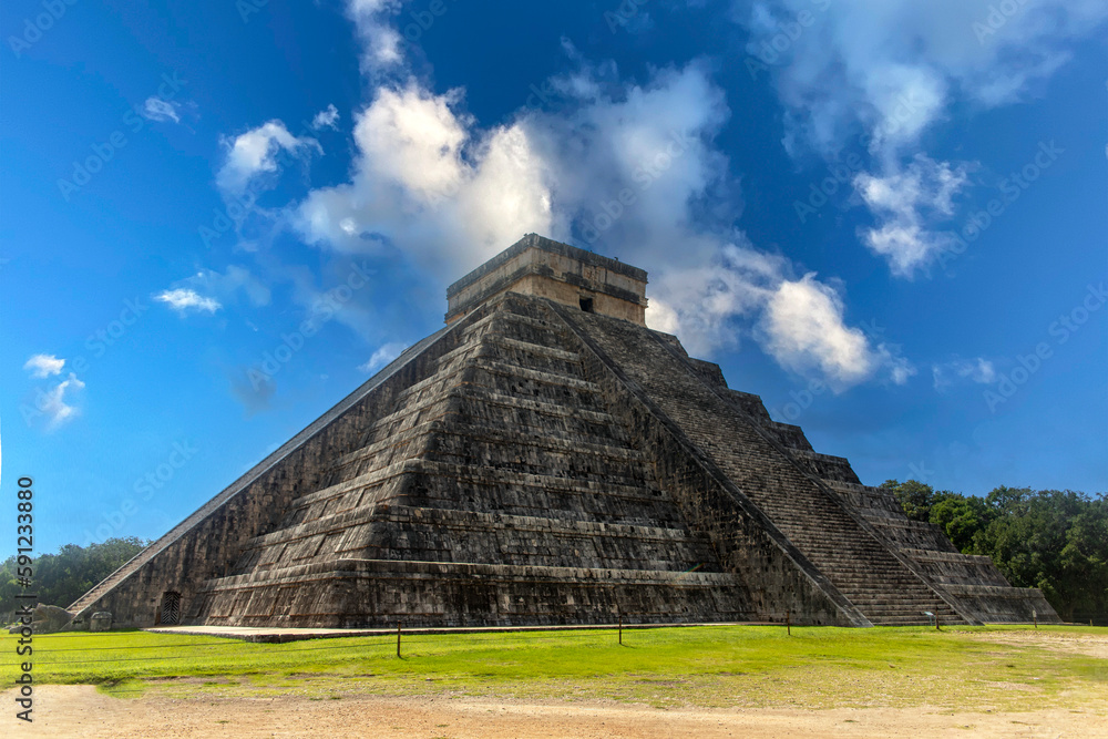 The pyramid of Chichen Itza in honor of the God Kukulkan the feathered serpent under a beautiful tropical blue sky, this castle of the Mayan civilization is one of the wonders of the world. The pyramid of Chichen Itza in honor of the God Kukulkan the feathered serpent under a beautiful tropical blue sky, this castle of the Mayan civilization is one of the wonders of the world.