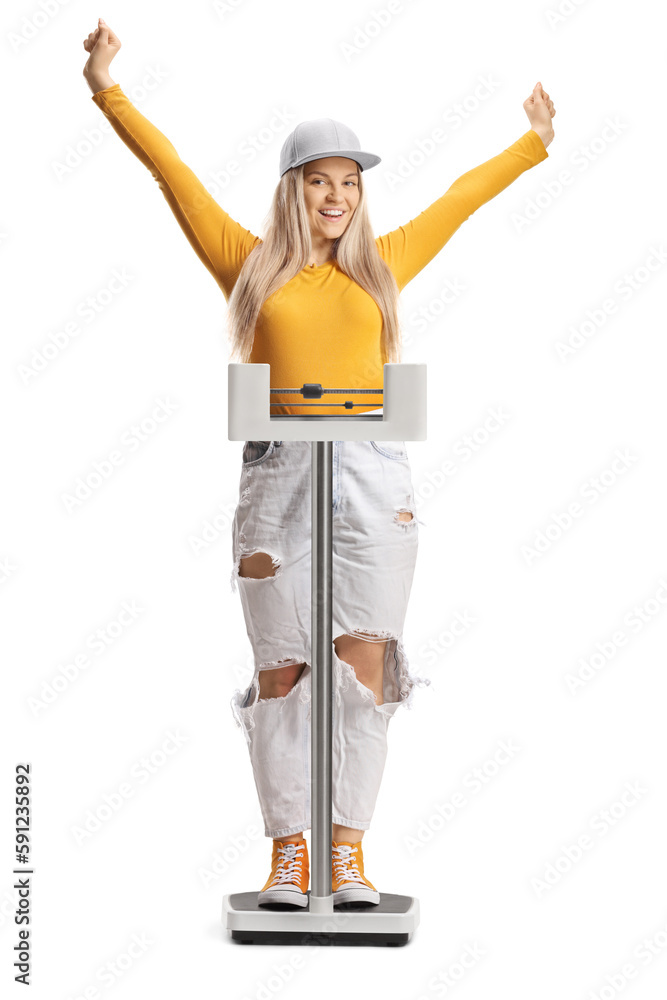 Young female weighing on a medical scale and gesturing happiness Young female weighing on a medical scale and gesturing happiness