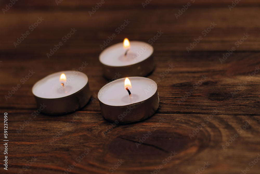 Three paraffin floating candles on a wooden table. Three paraffin floating candles on a wooden table.