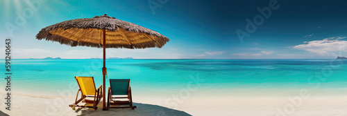 Panorama banner of two chairs and a sun umbrella on an exotic beach on a sunny day with clear blue water and sunny sky.
