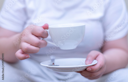 Women holding a cup of coffee and drinking coffee