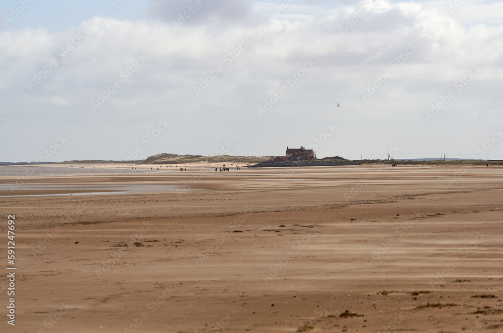 Distant figures on a beach in Norfolk, UK Distant figures on a beach in Norfolk, UK
