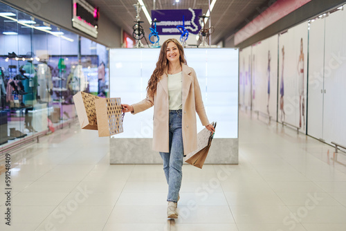 Happy Girl with paper shopping bags. Consumerism and lifestyle concept. Woman in shopping.