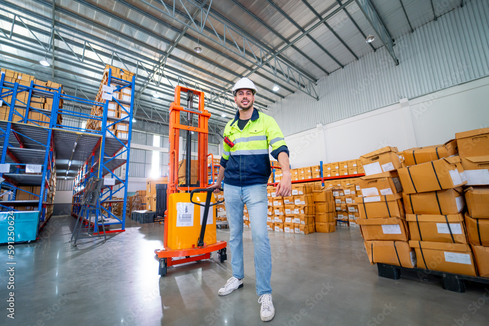 Naklejka premium Caucasian warehouse worker man action of pull cargo small truck that carry product boxes in area of workplace.