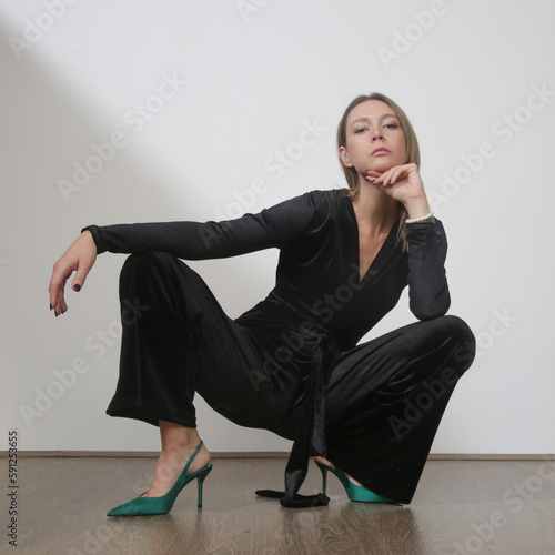 Serie of studio photos of young female model in elegant plush black jumpsuit photo