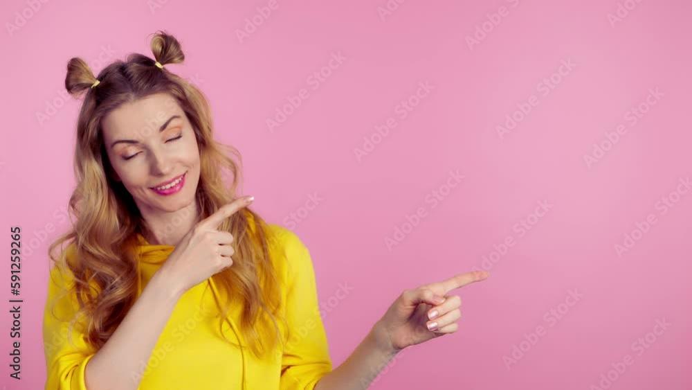 Woman and pointing at mockup workspace for advertisement, marketing, promotion or text. Female model happy smiling showing mock up for news deal of offer in studio on pink background Woman and pointing at mockup workspace for advertisement, marketing, promotion or text. Female model happy smiling showing mock up for news deal of offer in studio on pink background