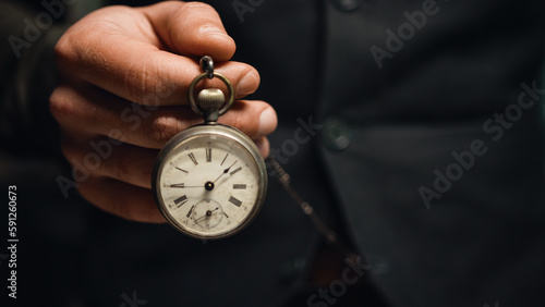 Man holds pocket watch in hand photo