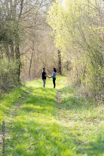 jeune couple amoureux dans un chemin vert en forêt © Esta Webster