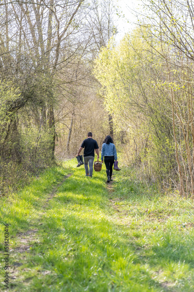balade d'un jeune couple dans les bois dans un joli chemin avec un panier et des bottes balade d'un jeune couple dans les bois dans un joli chemin avec un panier et des bottes