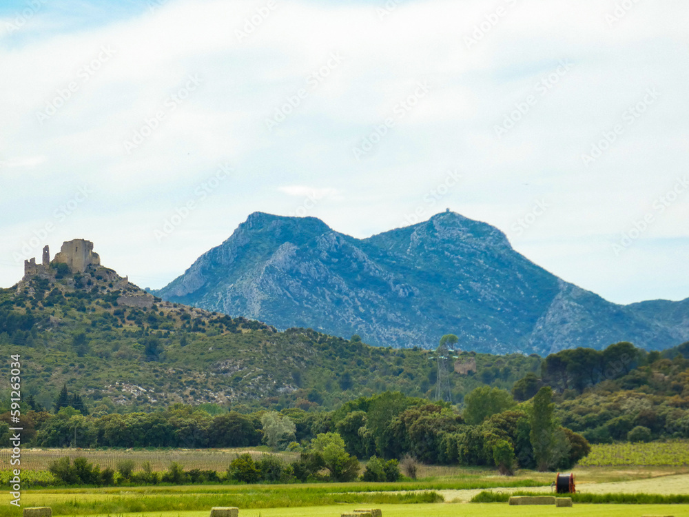 Exceptional landscape where we see on the same photo on the left the ruins of the castle of Queen Jeanne and in the center the mountain of Opies in the Alpilles in Provence in France