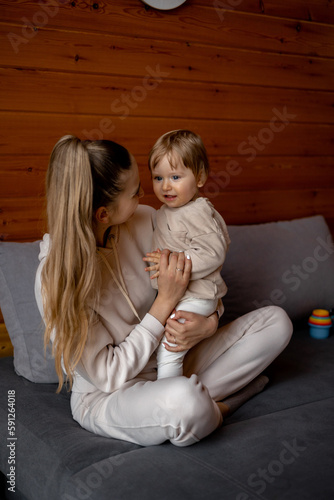 A woman sits on a couch with her baby