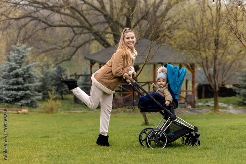 A woman in a park with a baby in a stroller