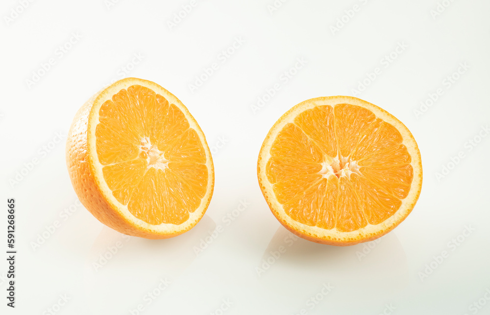 Two halves of an orange with reflection on a white mirror background Two halves of an orange with reflection on a white mirror background