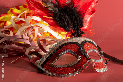 Venetian carnival mask with feathers, and typical elements in the background