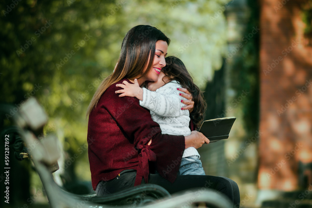 Mom story telling a stories to her little girl. Mom and daughter spend ...