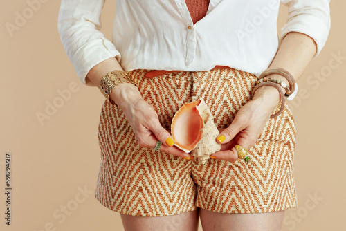 Modern female in blouse and shorts isolated on beige photo