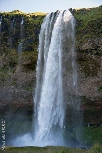 Seljalandsfoss gorge  in Iceland. Incidental people behind the water