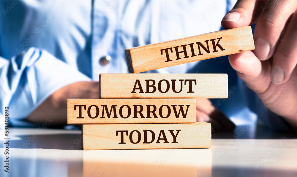 Close up on businessman holding a wooden block with "Think about tomorrow today" message - obrazy, fototapety, plakaty 