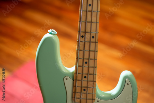 Canvas Print Close-up of green surf colored electric bass with maple fingerboard