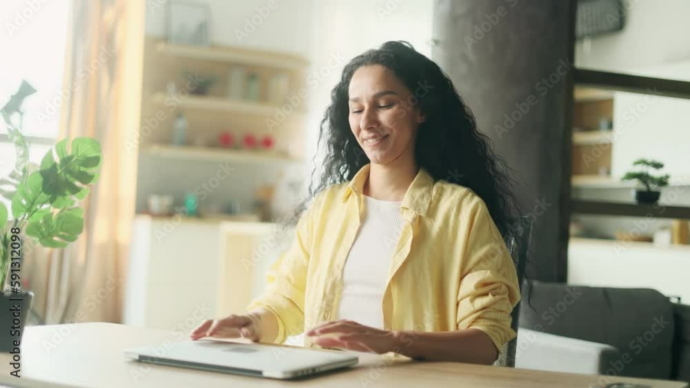 Beautiful inspired young hispanic woman stretches before productive working day at the laptop computer at home office Smiling curly freelancer enjoying great day with distance remote work indoors Beautiful inspired young hispanic woman stretches before productive working day at the laptop computer at home office Smiling curly freelancer enjoying great day with distance remote work indoors