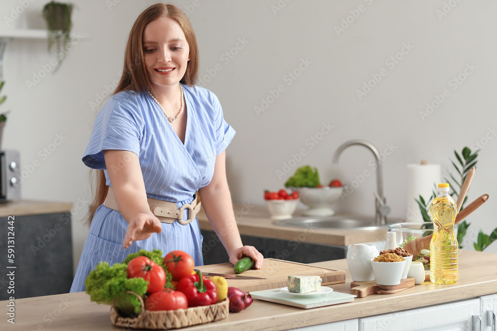 Young woman making vegetable salad in kitchen Young woman making vegetable salad in kitchen