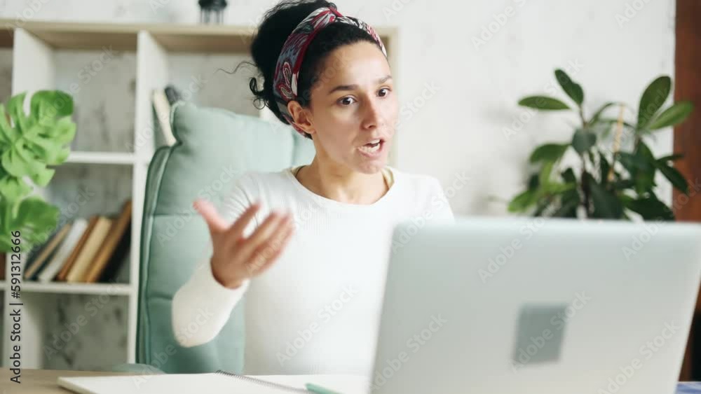 Irritated arguing young hispanic woman looking at laptop screen yelling indoors Angry nervous female expressing negative emotion and shows fists by online conference meeting Bad conflict conversation Irritated arguing young hispanic woman looking at laptop screen yelling indoors Angry nervous female expressing negative emotion and shows fists by online conference meeting Bad conflict conversation