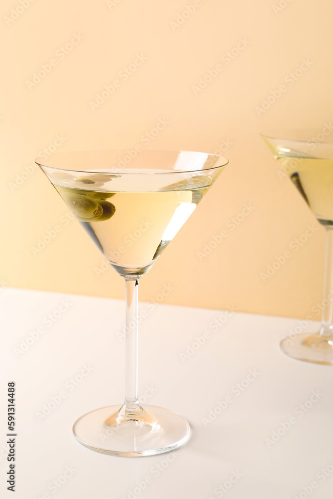 Glasses of martini with olives on beige background Glasses of martini with olives on beige background