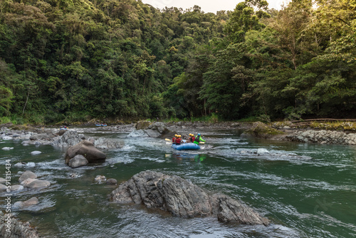 group of tourists rafting on a raft in the middle of the jungle on the Pacuare River in Costa Rica photo