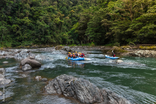 group of tourists rafting on a raft and kayak in the middle of the jungle on the Pacuare River in Costa Rica