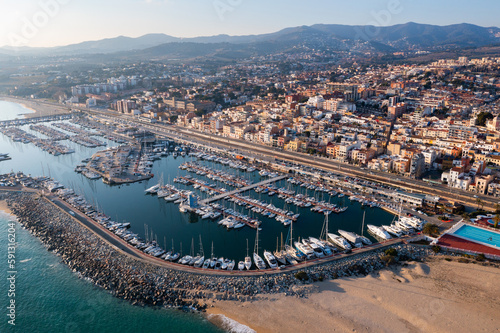 Aerial photo of Spanish town El Masnou with view of buildings along seashore and quay. photo