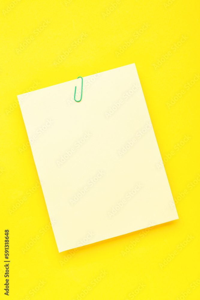 Paper sheet with clip on yellow background Paper sheet with clip on yellow background