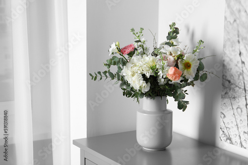 Bouquet with beautiful flowers on light gray chest of drawers indoors. Space for text © New Africa