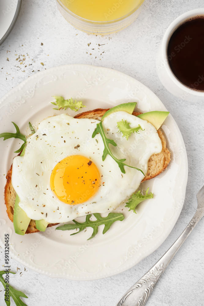 Delicious sandwich with fried egg, arugula and avocado on light background Delicious sandwich with fried egg, arugula and avocado on light background