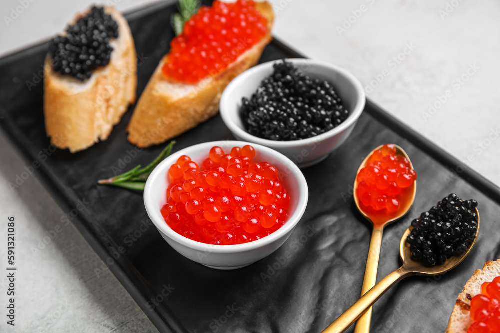 Tasty bruschettas with red and black caviar on light background Tasty bruschettas with red and black caviar on light background