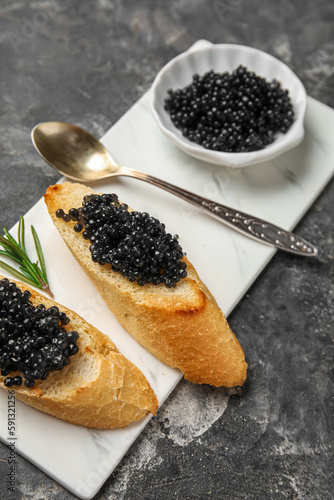 Tasty bruschettas with black caviar on dark grunge background