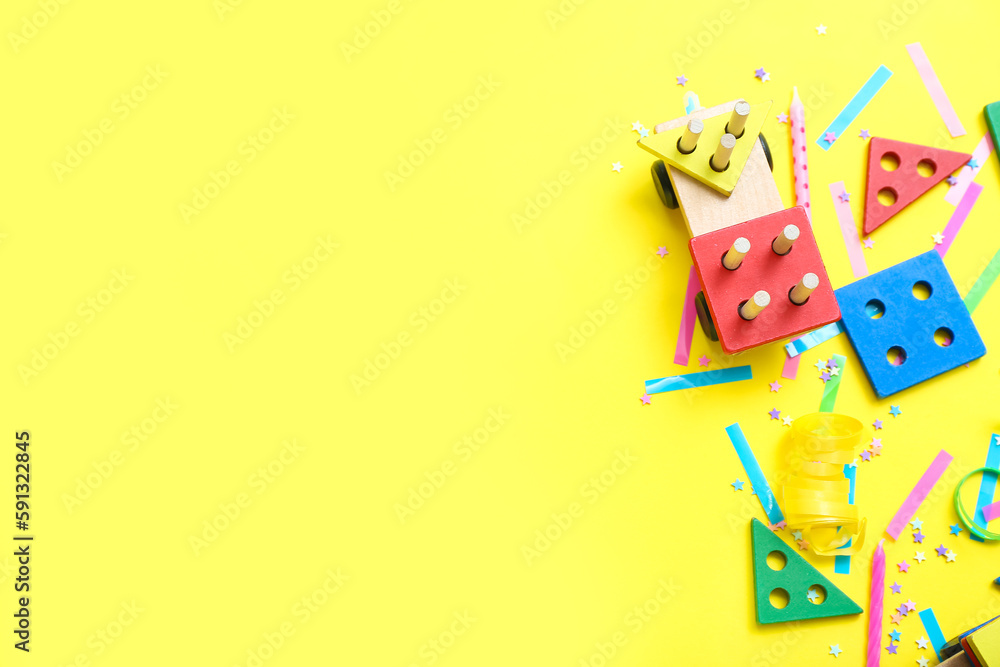 Obraz premium Baby blocks with confetti on yellow background. Children's Day celebration