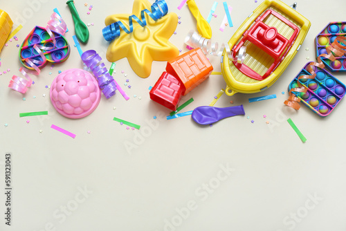 Baby toys with confetti and balloons on beige background. Children's Day celebration
