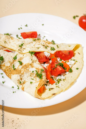 Tasty omelet with tomatoes on beige background