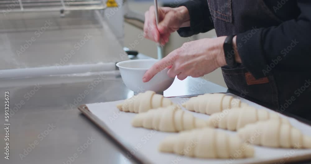 Woman baker preparing raw dough for pastry on baking manufacture Woman baker preparing raw dough for pastry on baking manufacture