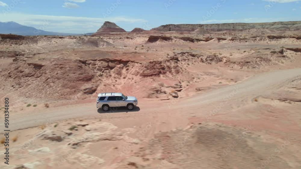 Side-by-side drone shot of Toyota 4Runner car driving in Utah desert Side-by-side drone shot of Toyota 4Runner car driving in Utah desert