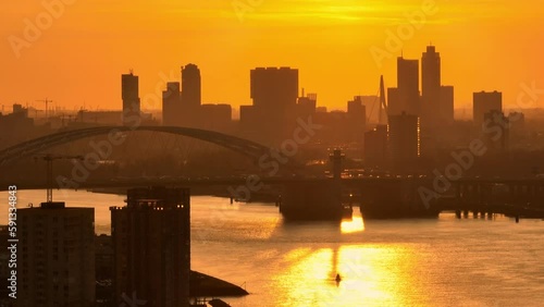 Van Brienenoord bridge traffic at golden hour; Rotterdam skyline in orange sky photo