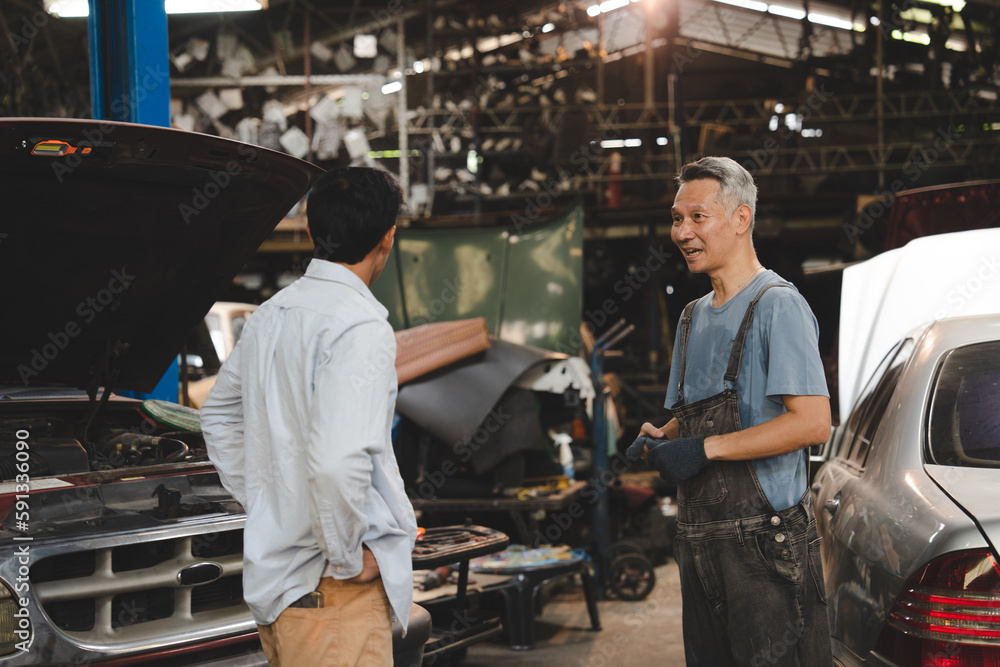 Vehicle automotive service guy worker doing check or mend car wheel, Asian mechanic repairman look under car condition to work in inspection workshop or maintenance to repair car engine in garage Vehicle automotive service guy worker doing check or mend car wheel, Asian mechanic repairman look under car condition to work in inspection workshop or maintenance to repair car engine in garage