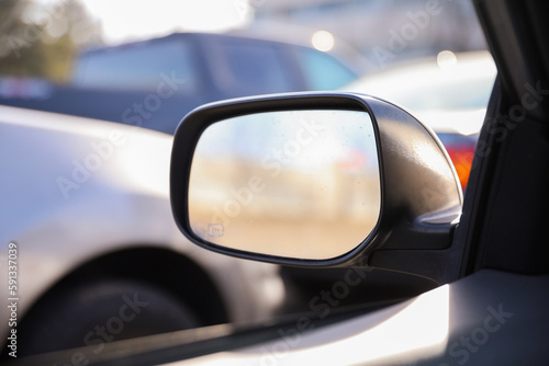Car mirror in a stock photo symbolizes reflection, perspective, and awareness. It represents the importance of looking back, being mindful of surroundings, and gaining insights from past experiences  © Your Hand Please