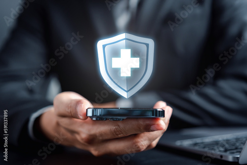 Health insurance concept. Businessman using smartphone using online service healthcare medical protection icon, health and access to welfare health concept. © Kiattisak