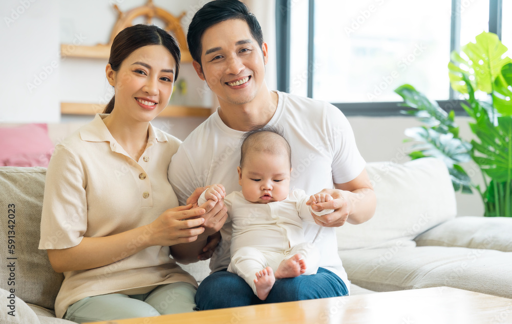 Smiling mother and father holding newborn son at home