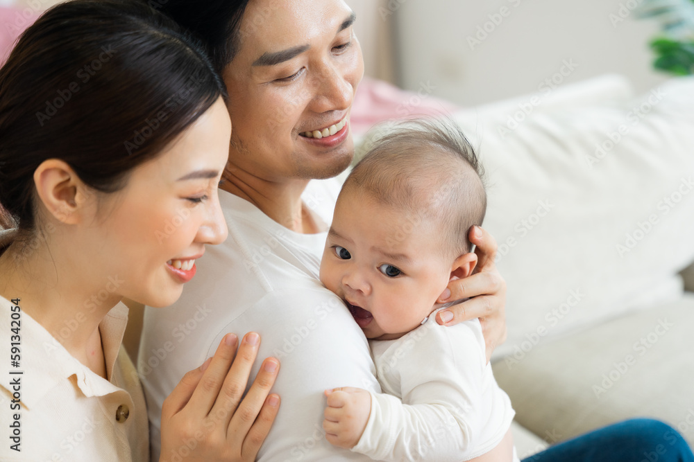 Smiling mother and father holding newborn son at home Smiling mother and father holding newborn son at home